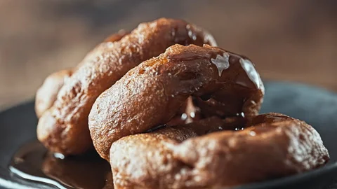 Traditional Peruvian picarones with sweet chancaca syrup drizzle. Stock Footage 344988134