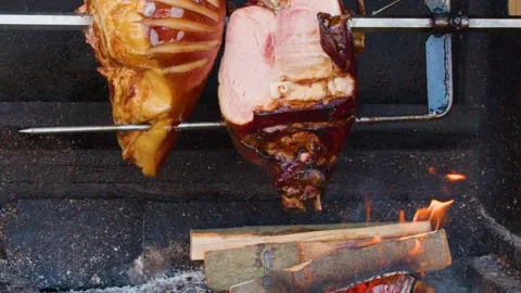 Traditional Pork Knuckle Rotating on Spit Over Open Wood Fire Stock Footage 326022345