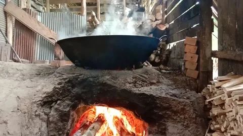 Traditional process of making palm sugar, cooking raw palm extract on traditi Stock Footage 142135708