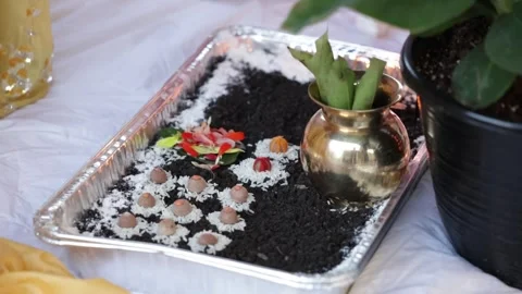 A traditional puja setup featuring a decorative tray with rice, flowers, and Stock-Footage 316301447