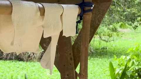 Traditional Raw Rubber Latex Sheets Drying on Wooden Racks Outdoors Video stock 325760196