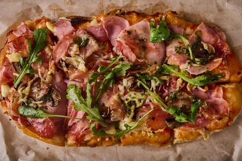 Traditional rectangular Roman pizza with prosciuto ham, tomatoes, mozzarella Stock Photos