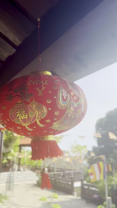 Traditional red decorations with golden patterns and tassels hang under a w.. Stock Footage 339444377