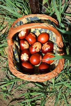 Traditional red easter eggs in wicker basket on grass spring holiday folk market Stock Photos