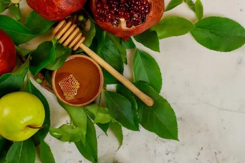 Traditional Rosh Hashanah composition includes apple, pomegranate, and honey. Stock Photos