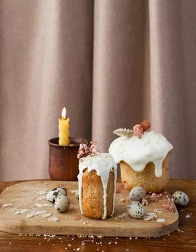 Traditional Russian Easter cake with icing and candle quail eggs on a wooden  Stock Photos