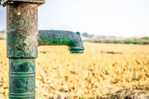 A traditional rusty hand pump to control drinking water crisis Stock Photos