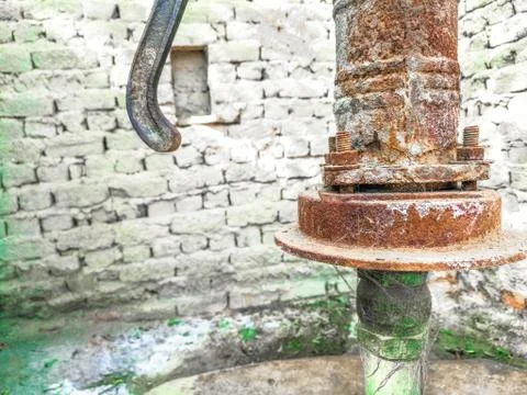A traditional rusty hand pump to control drinking water crisis Stock Photos