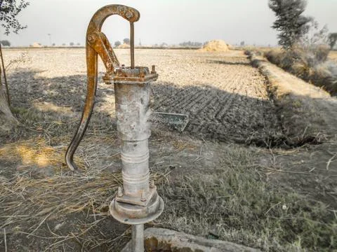 A traditional rusty hand pump to control drinking water crisis Stock Photos
