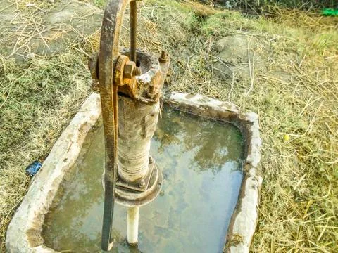 A traditional rusty hand pump to control drinking water crisis Stock Photos