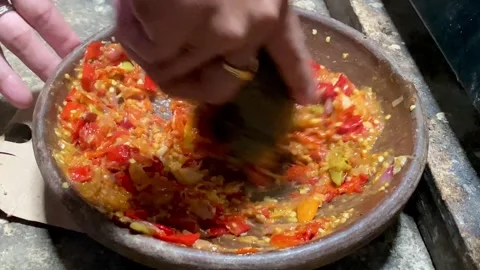 Traditional Sambal Preparation Using Stone Mortar Stock Footage 325549748