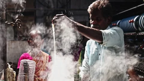 Traditional silk spinning process in india showing hands extracting raw golden Stock Footage 340412169