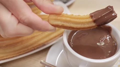 Traditional Spanish Breakfast: Dipping Churros in Hot Chocolate Stock Footage 253703853