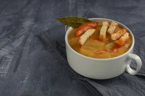 Traditional split pea soup with hard chucks in plate with handles. Фото