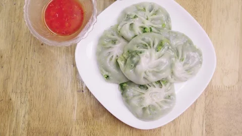 Traditional steamed vegetable chive dumplings on a white plate with spicy r.. Vídeos de archivo 340183891