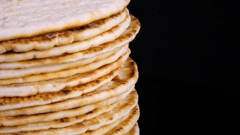 Traditional tasty flat bread (lavash, pita, chapati, scone) rotating on black 4K Vídeo Stock 86974953