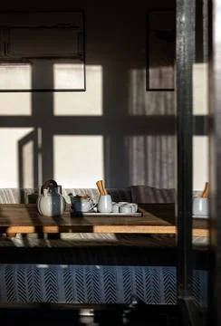A traditional tea set bathed in sharp, geometric slivers of afternoon sun. .. 写真素材