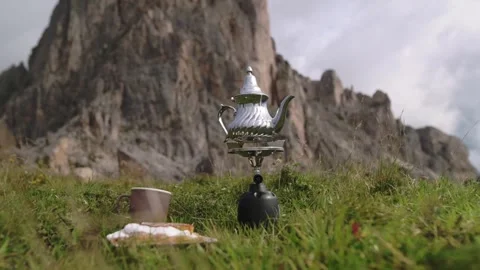 Traditional tea setup with silver teapot in alpine meadow in Dolomitines Alpes Stock Footage 318824209