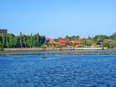 Traditional temple complex on the waterfront under a clear blue sky Stock Photos