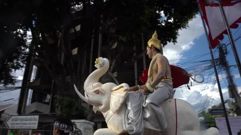 Traditional Thai parade float with costumed man riding white elephant statue Stock Footage 308988894