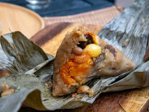 Traditional Thai sticky rice dumpling zongzi wrapped in dried leaves with s.. Foto stock