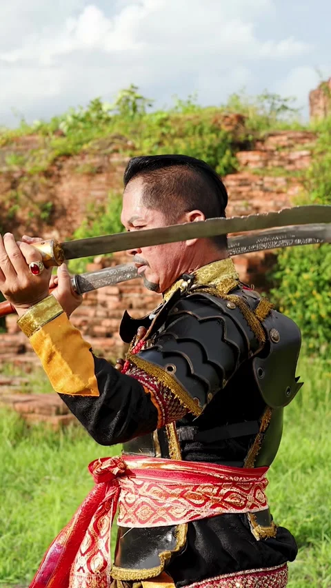 Traditional Thai Warrior Performing Martial Arts with Swords at Ancient Ruins Stock Footage 339870312