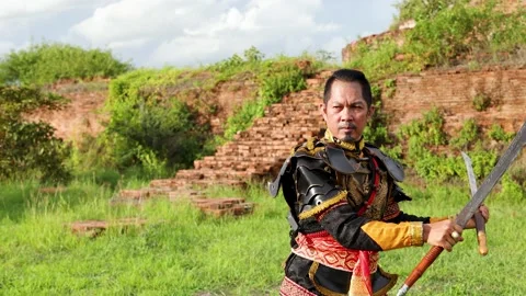 Traditional Thai Warrior Performing Sword Martial Arts at Ancient Ruins Stock Footage 338319675