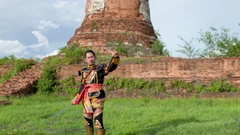 Traditional Thai Warrior Performing Sword Martial Arts at Ancient Temple Ruins Stock Footage 338319710