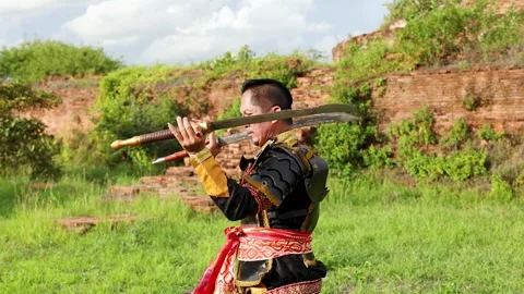Traditional Thai Warrior Performing Sword Martial Arts at Ancient Ruins Stock Footage 341075789