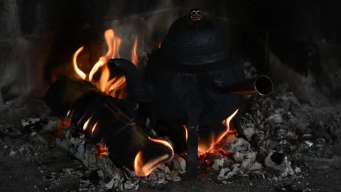 Traditional three-legged copper coffe pot in a fireplace Stock Footage 101096648