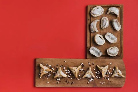 Traditional tibetan momo dumpling triangular shape wooden tray against red Foto stock