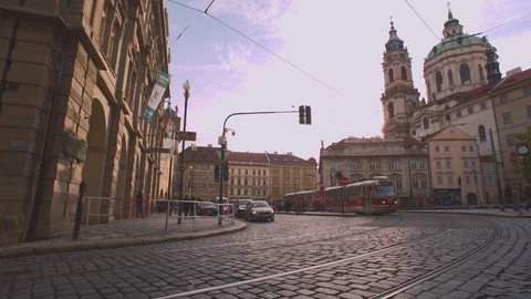 Traditional tram passing through square with church in the background in Stock Footage 126108560