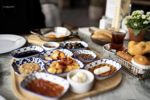 Traditional Turkish breakfast table with tea, eggs and small bowls Stock Photos