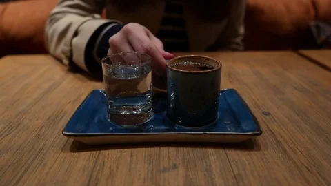 Traditional Turkish coffee served on square dish with glass of pure water Stock Footage 84794780