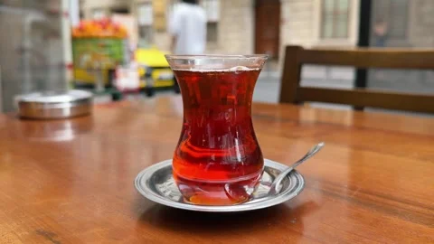 Traditional Turkish tea served in a tulip shaped glass on a wooden table in Stock Footage 323344053