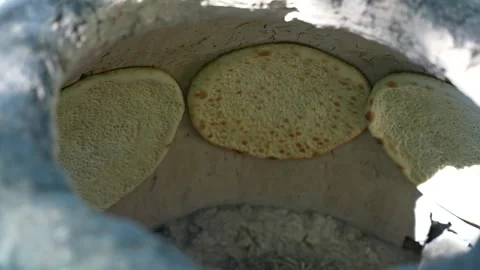 Traditional Turkmen flatbread baking in a clay oven, Central Asia food Stock Footage 346612993