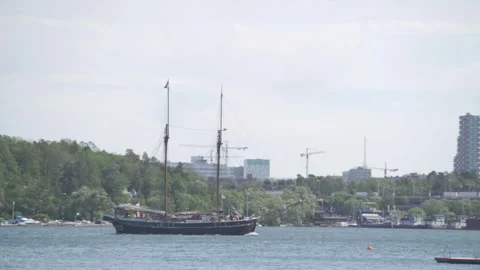 Traditional two-masted sailing ship navigating calm waters near stockholm Stock Footage 295911814