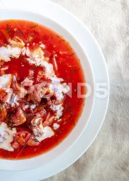 Traditional Ukrainian-Russian tomato borscht soup with sour cream in a white Stock Photos