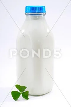 Traditional Vintage Square Glass Milk Bottle Full Of Milk With Shamrock Leaf Stock Photos