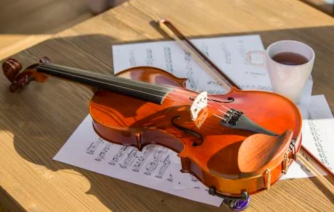 Traditional violin, coffee and notes on wooden table Stock Photos