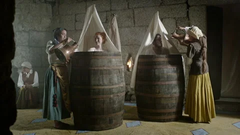 Traditional washing methods in a historic setting with barrels and people Stock Footage 327946426
