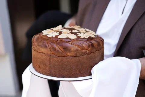 Traditional wedding bread with decorative patterns is ceremonially presented  写真素材