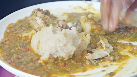 Traditional West African eba swallow and okra soup plate Stock Footage 339229155