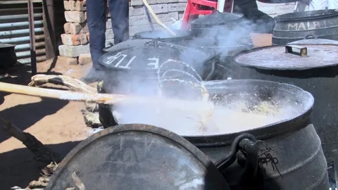 Traditional White Maize Pap Stirred in a traditional black cast iron over a.. Stock Footage 331672853