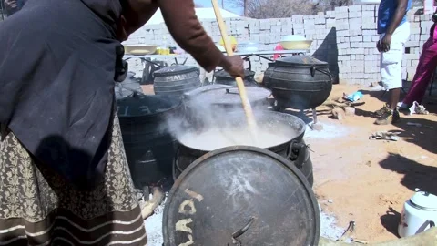 Traditional White Maize Pap Stirred in a traditional black cast iron over a.. Stock Footage 331874583