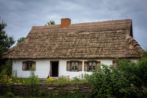A traditional, white wooden house with thatched roof and garden. Stock Photos