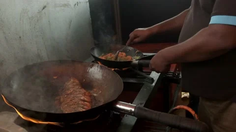 Traditionally cooked fish lies in a pan with boiling oil and delicious sauce  Stock Footage 139500146