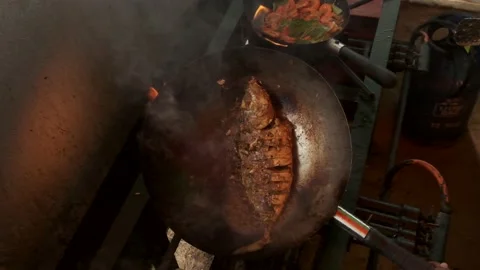 Traditionally cooked fish lies in a pan with boiling oil and delicious sauce  Stock Footage 139500153