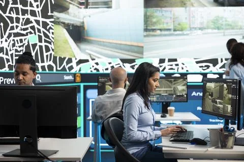 Traffic analysts sitting at PC desks reviewing live road camera footage Stock Photos