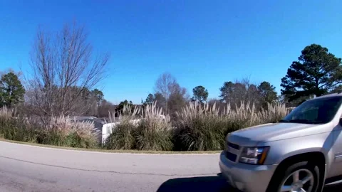 Traffic and a trailer park behind shrubs on a clear blue sky day Stock Footage 171303719